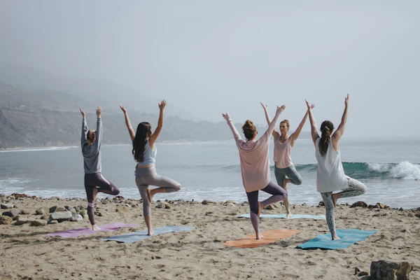 Grupo praticando yoga na praia